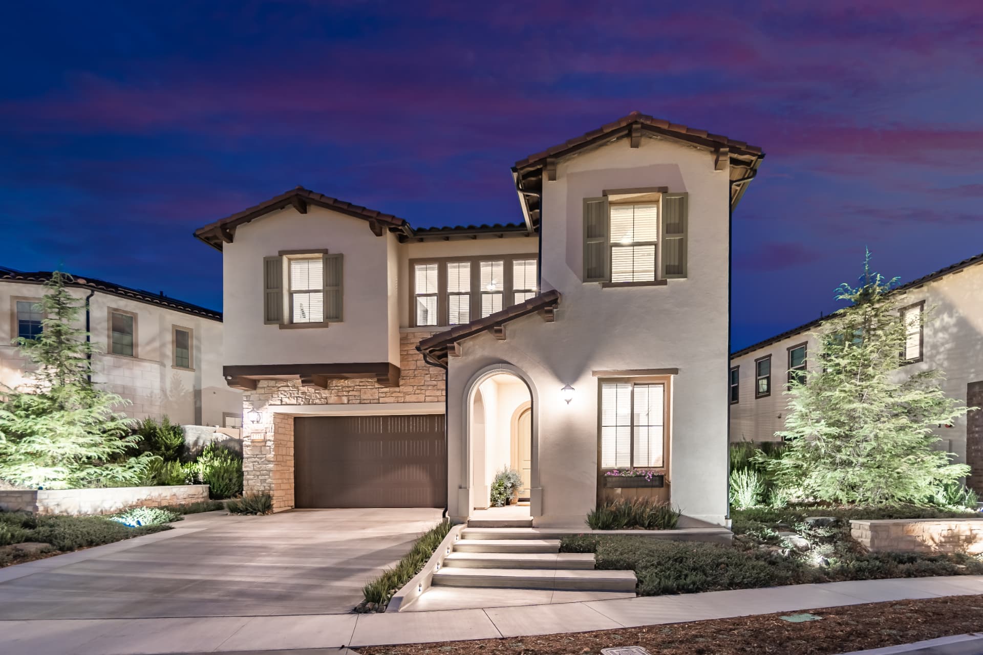 Mediterranean-style two-story home with exterior lighting at night in Lake Forest